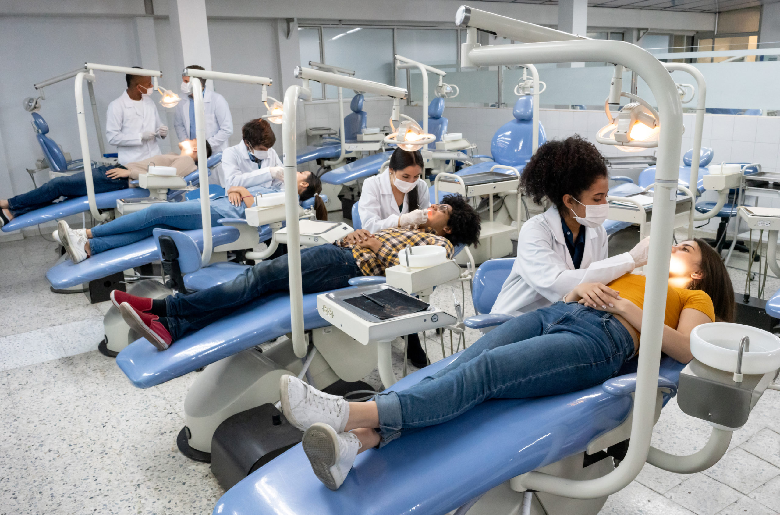 Students at dental school examining the teeth of some patients