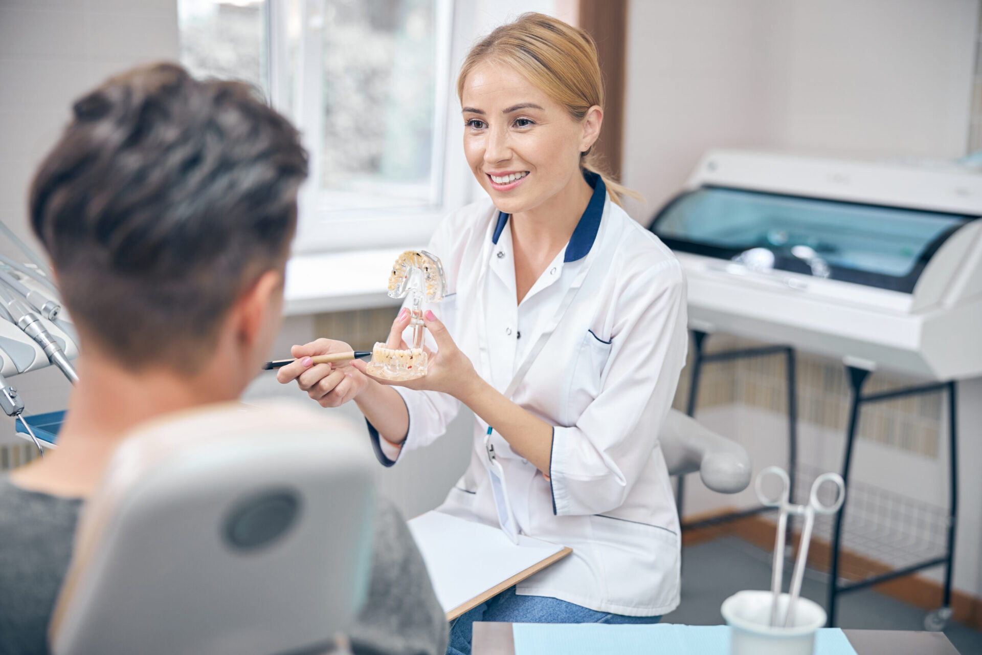 Jolly female dentist during man visit in office