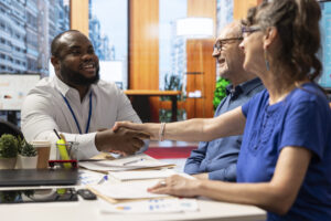 Financial expert sharing a handshake with old woman client