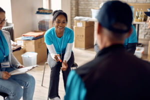 Happy black volunteer talking to her coordinator during a meeting at humanitarian aid center.
