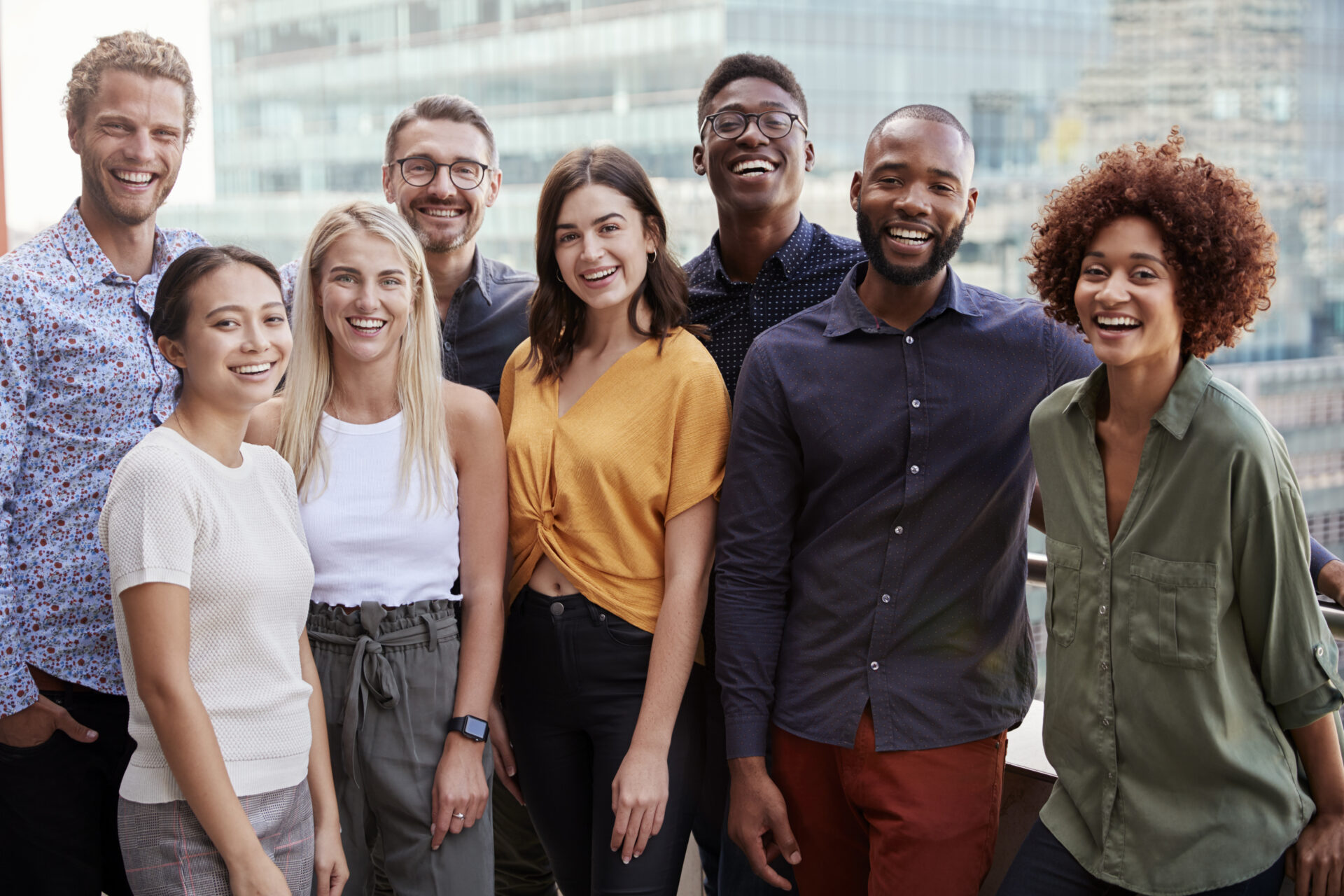 Group portrait of a creative business team standing outdoors, three quarter length, close up